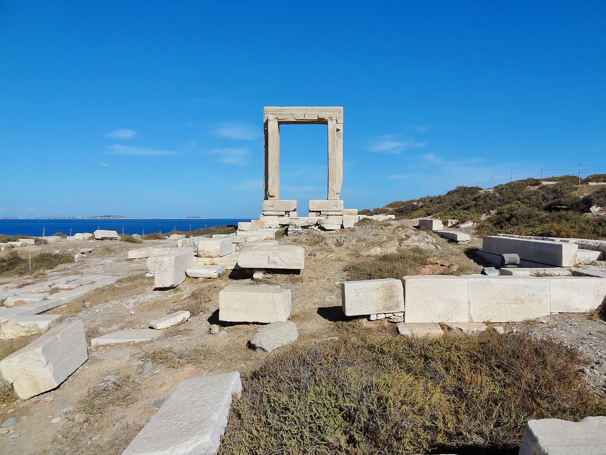 The Portara temple gate seen from its marble mound on the Palatia islet with the sea horizon behind